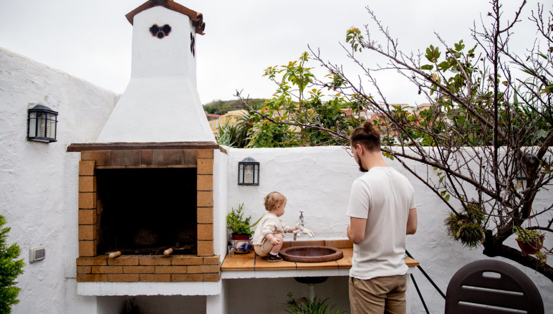 Man and child at an outdoor kitchen